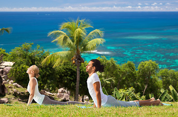 Image showing couple making yoga cobra pose outdoors