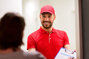 Image showing deliveryman with clipboard at customer home