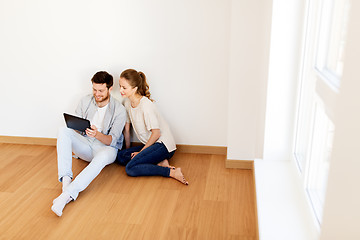 Image showing happy couple with tablet pc computer at new home