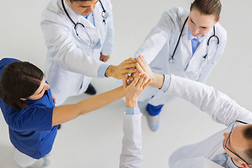 Image showing group of doctors making high five at hospital