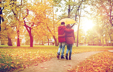 Image showing happy couple with umbrella walking in autumn park