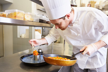 Image showing happy male chef cooking food at restaurant kitchen