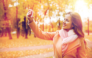 Image showing woman taking selfie by smartphone in autumn park