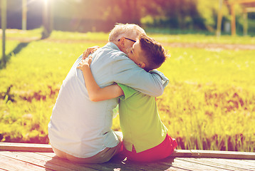 Image showing grandfather and grandson hugging on berth