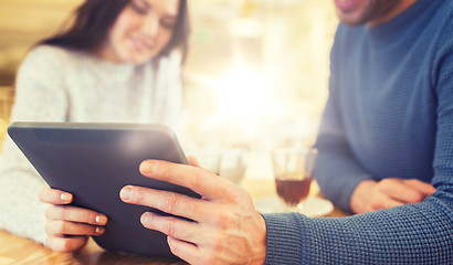 Image showing happy couple with tablet pc drinking tea at cafe