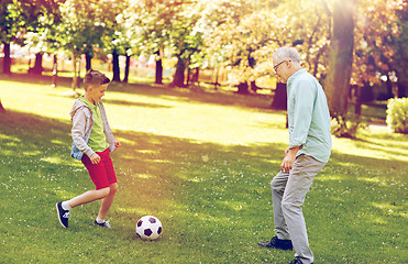 Image showing old man and boy playing football at summer park