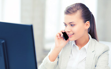 Image showing businesswoman with smartphone in office