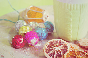 Image showing Cup, christmas balls and cuted fruits, retro toned