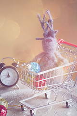 Image showing Christmas decorations and elk in shopping trolley, retro toned