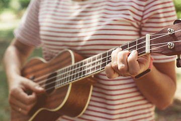 Image showing Anonymous woman playing ukulele