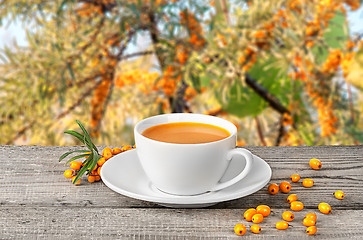 Image showing Tea of seabuckthorn berries on wooden table