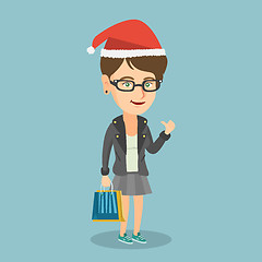 Image showing Woman in santa hat shopping for christmas gifts.