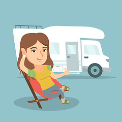 Image showing Woman sitting in a chair in front of camper van.