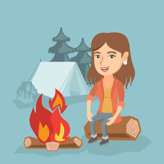 Image showing Woman sitting on log near campfire in the camping.