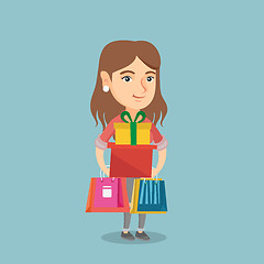 Image showing Young woman holding shopping bags and gift boxes.