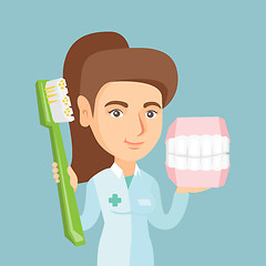 Image showing Dentist with a dental jaw model and a toothbrush.