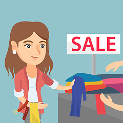 Image showing Young woman choosing clothes in the shop on sale.