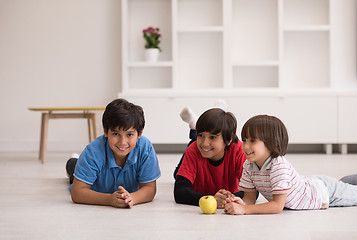 Image showing boys having fun with an apple on the floor