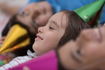 Image showing kids  blowing confetti while lying on the floor