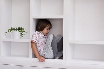 Image showing young boy posing on a shelf