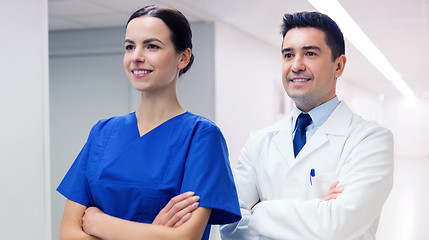 Image showing smiling doctor in white coat and nurse at hospital