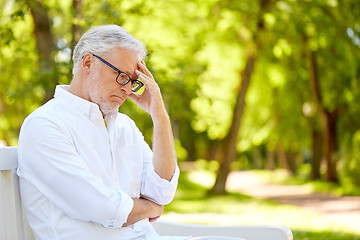 Image showing thoughtful senior man sitting at summer park