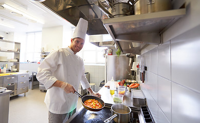 Image showing happy male chef cooking food at restaurant kitchen