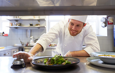 Image showing happy male chef cooking food at restaurant kitchen