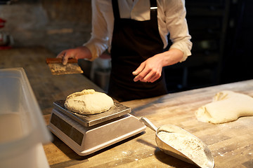 Image showing chef or baker weighing dough on scale at bakery