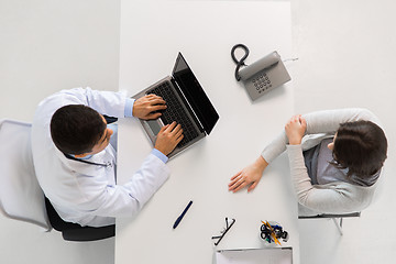 Image showing doctor with laptop and woman patient at hospital