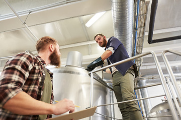 Image showing men with clipboard at brewery or beer plant kettle