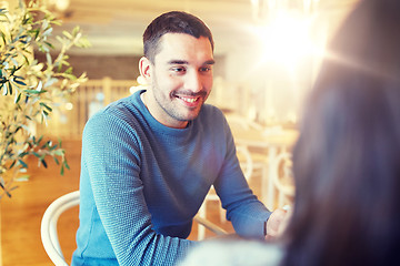 Image showing happy couple talking at cafe or restaurant