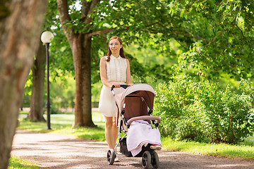 Image showing happy mother with child in stroller at summer park