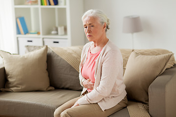 Image showing senior woman suffering from stomach ache at home