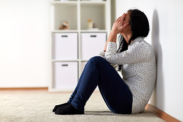 Image showing unhappy woman crying on floor at home