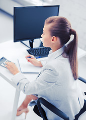 Image showing businesswoman with notebook and calculator