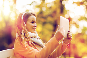 Image showing woman with tablet pc and headphones in autumn park