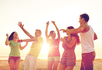 Image showing smiling friends dancing on summer beach