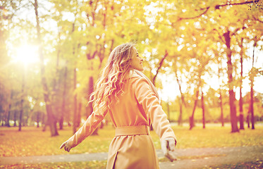 Image showing beautiful happy young woman walking in autumn park