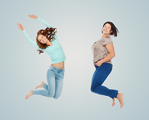 Image showing happy different women jumping over blue