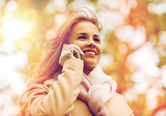 Image showing woman calling on smartphone in autumn park