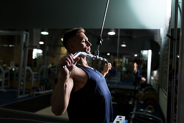 Image showing man flexing muscles on cable machine in gym