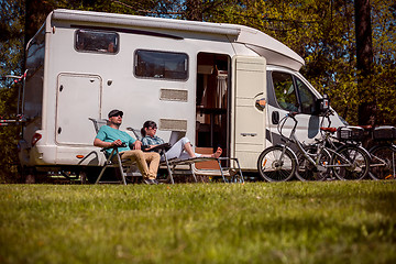 Image showing Woman with a man resting near motorhomes in nature. Family vacat