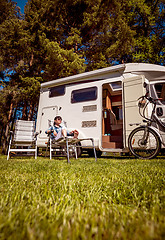 Image showing Woman resting near motorhomes in nature. Family vacation travel,