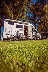 Image showing Woman resting near motorhomes in nature. Family vacation travel,