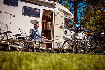 Image showing Woman resting near motorhomes in nature. Family vacation travel,