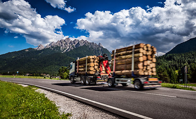 Image showing Timber truck rushes down the highway in the background the Alps.