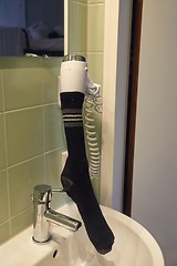 Image showing Drying sock in a hairdryer