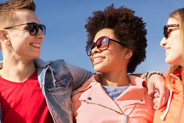 Image showing happy teenage friends in shades talking on street