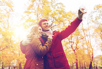 Image showing couple taking selfie by smartphone in autumn park